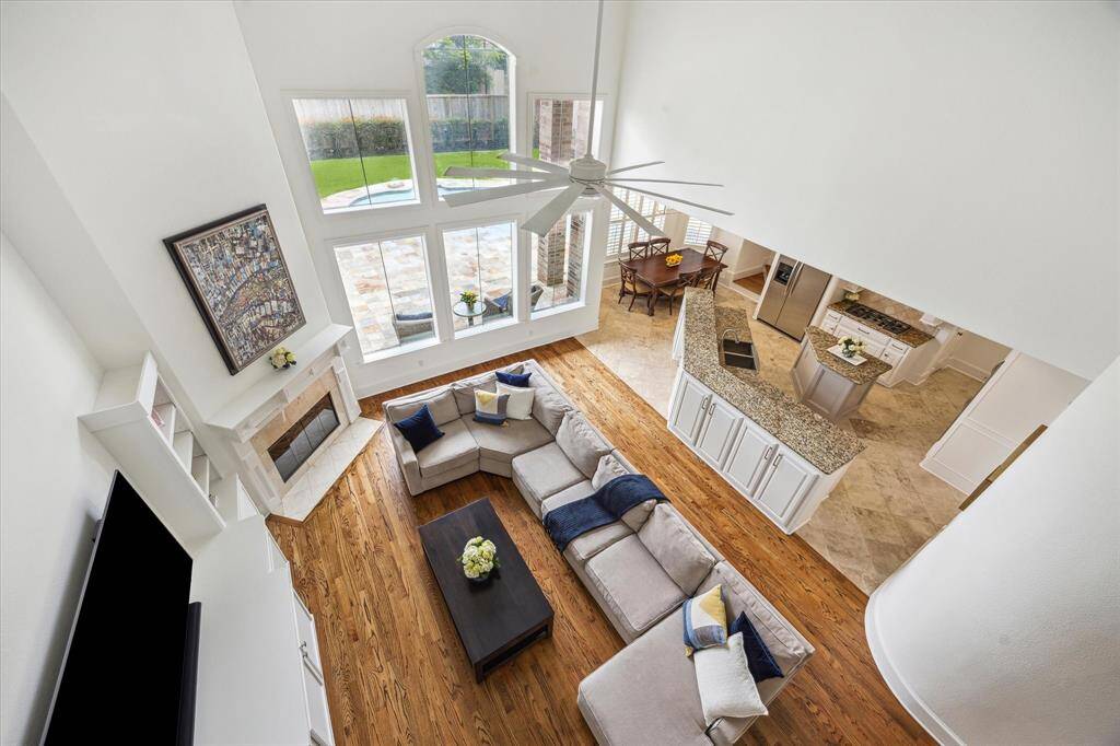 View from 2nd floor landing of the family room, kitchen, breakfast area with outdoor views.