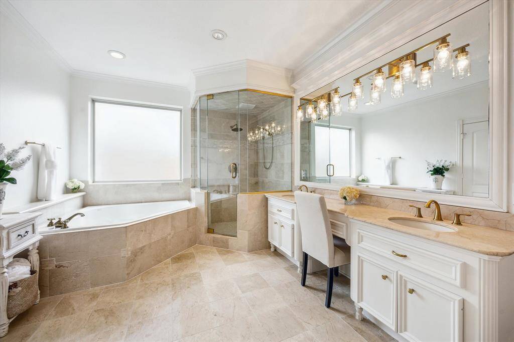 Luxurious primary bath features vanity with double sinks, separate shower and tub.