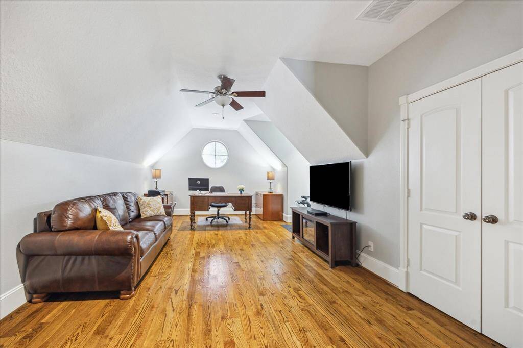 5th bedroom with dormer ceiling design and porthole window. Owner is currently utilizing the room as a home office.