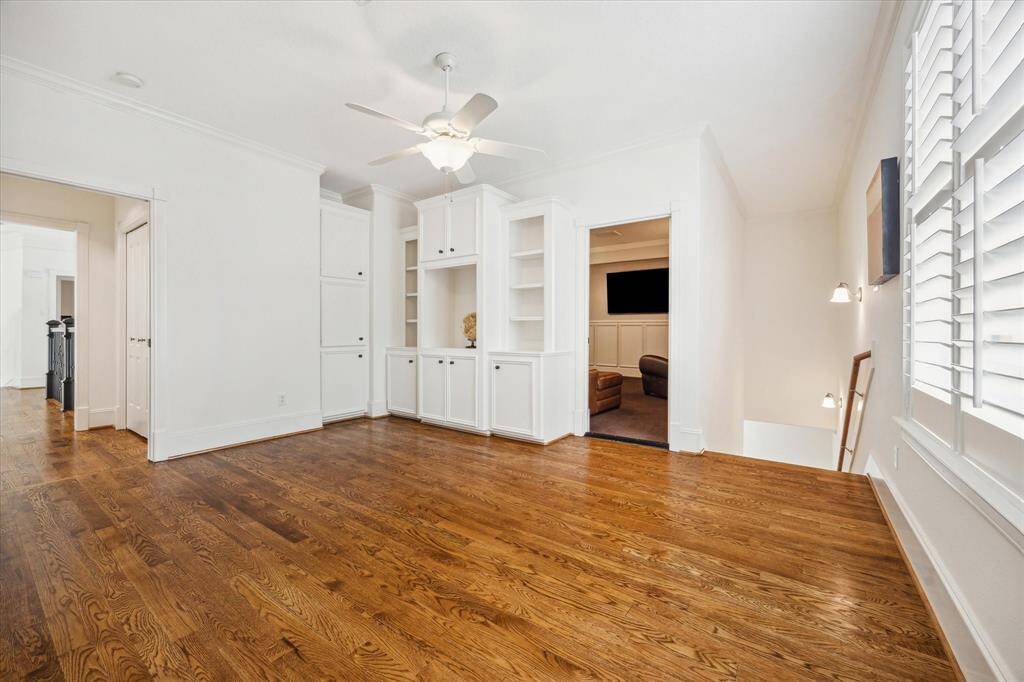 Game room located off back staircase to kitchen with built-in cabinetry, shelving and access to media room.