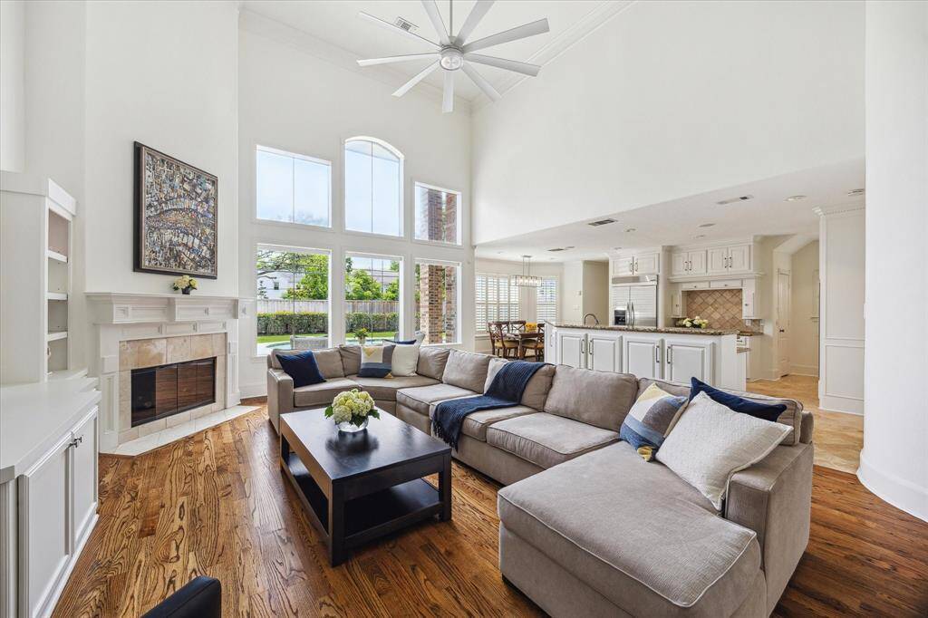 Open family room with 2 story ceilings, wall of glass with views of patio, backyard and pool open to the kitchen and breakfast area for informal living.