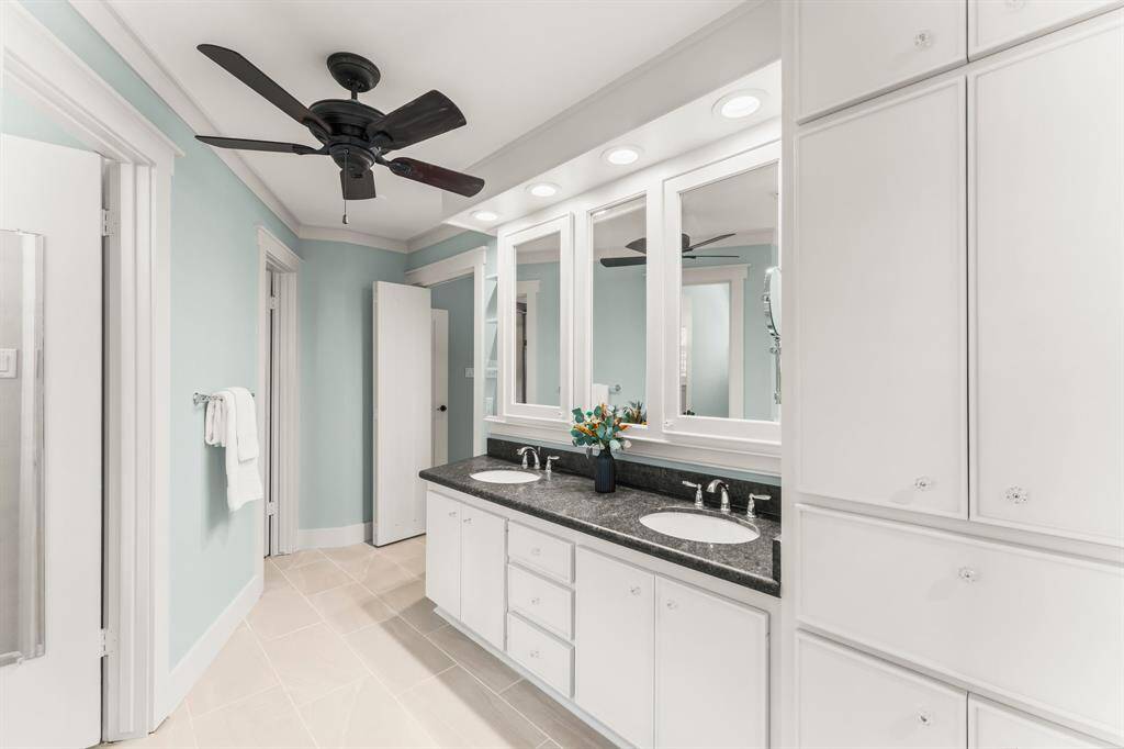 Storage is not lacking with his and her closets, vanity storage behind the mirrors, and cabinetry.