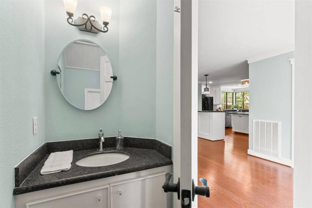 The half bath is located under the stairs just off the entryway.