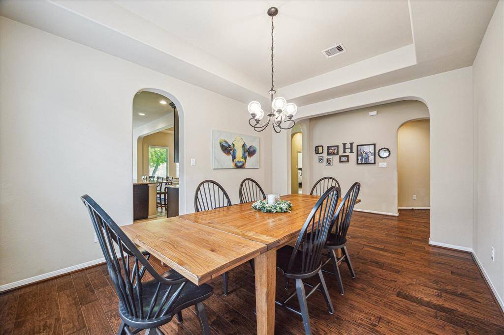 Gather them around your table to honor old traditions and create the new. This elegant formal dining room offers the perfect setting for all occasions with beautiful wood flooring, neutral paint, a raised tray ceiling with a stylish chandelier.