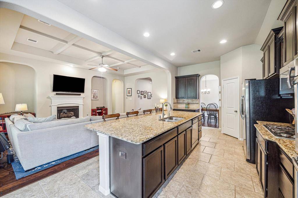 This thoughtfully designed kitchen sits at the heart of the home, opening to a casual dining area on one end and a formal dining room on the other. With an oversized island and bar seating, it’s the perfect setup for everyday living and easy entertaining.