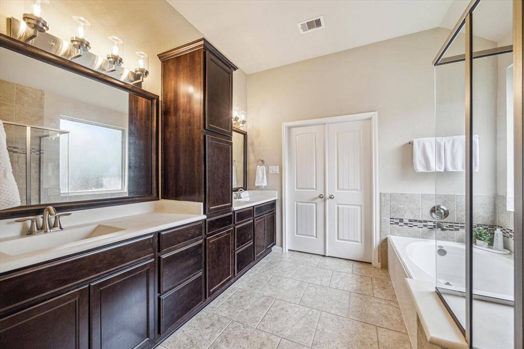 The primary ensuite has everything you need to start the day refreshed or wind down in comfort, featuring an expansive dual sink vanity, a relaxing soaking tub, and a separate walk-in shower.