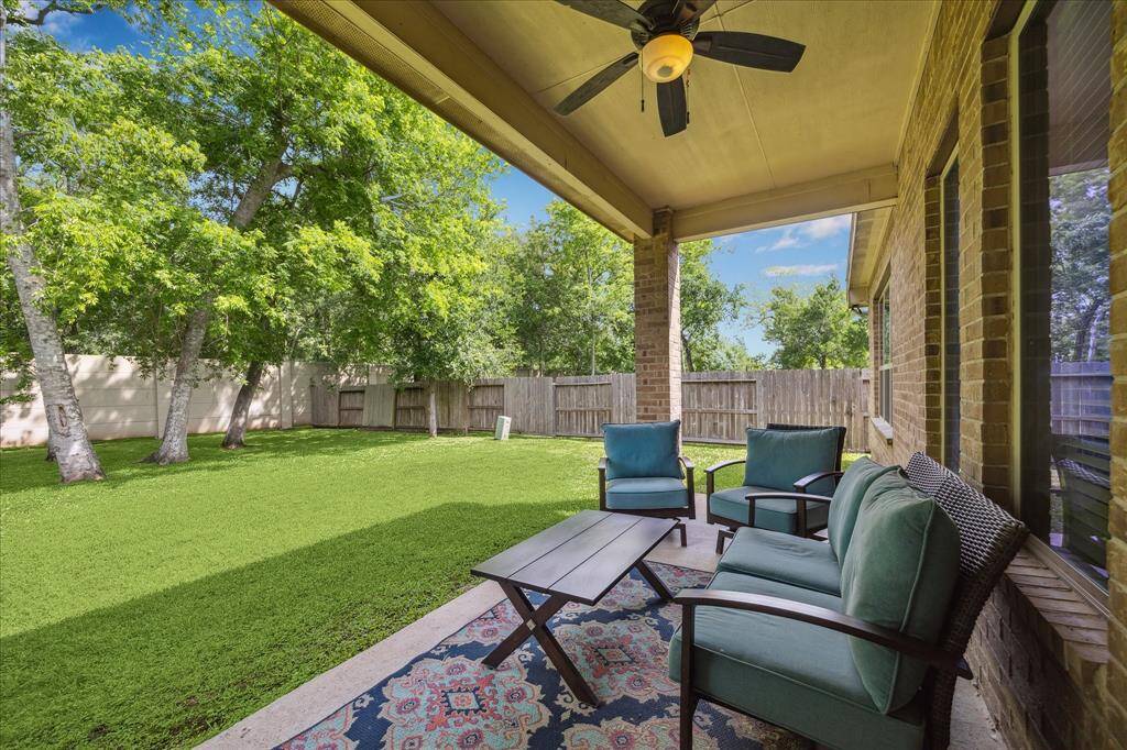 Enjoy your morning coffee or evening wind-down on this charming covered patio, complete with a cooling fan, plenty of room for outdoor seating, and a peaceful view of the wooded yard.