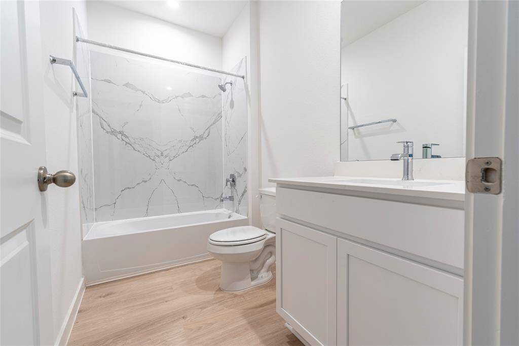 Downstairs second bathroom with large format tile around the tub for easy maintenance.