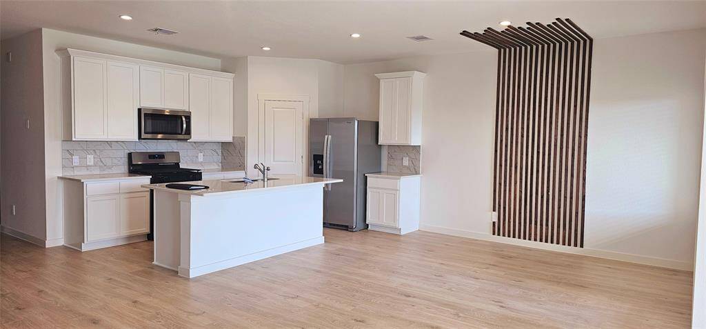 Open concept kitchen and dining. Quartz countertops and beautiful backsplash.