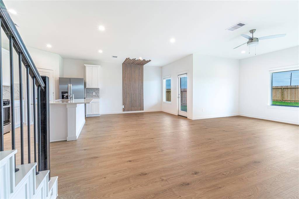 Luxurious and modern feel with natural oak luxury vinyl plank flooring and a dining wall accent.