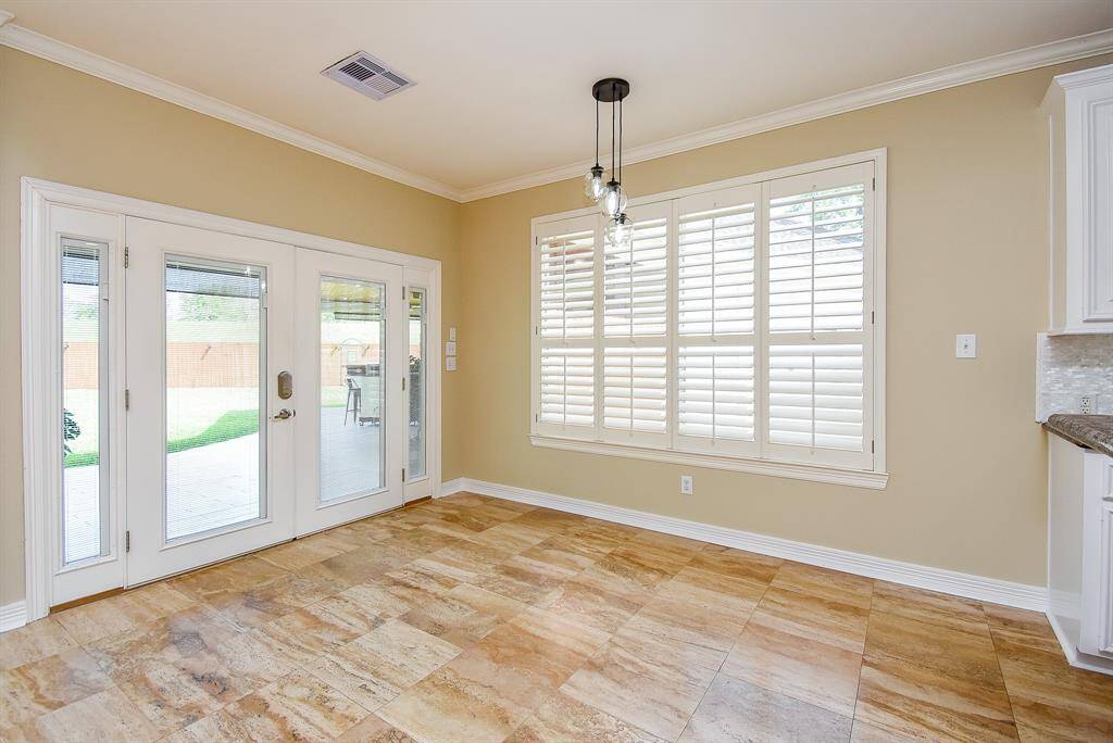 The seller replaced the single entry backdoor with French doors! Custom Plantation shutters, crown molding, and updated hanging light fixture.