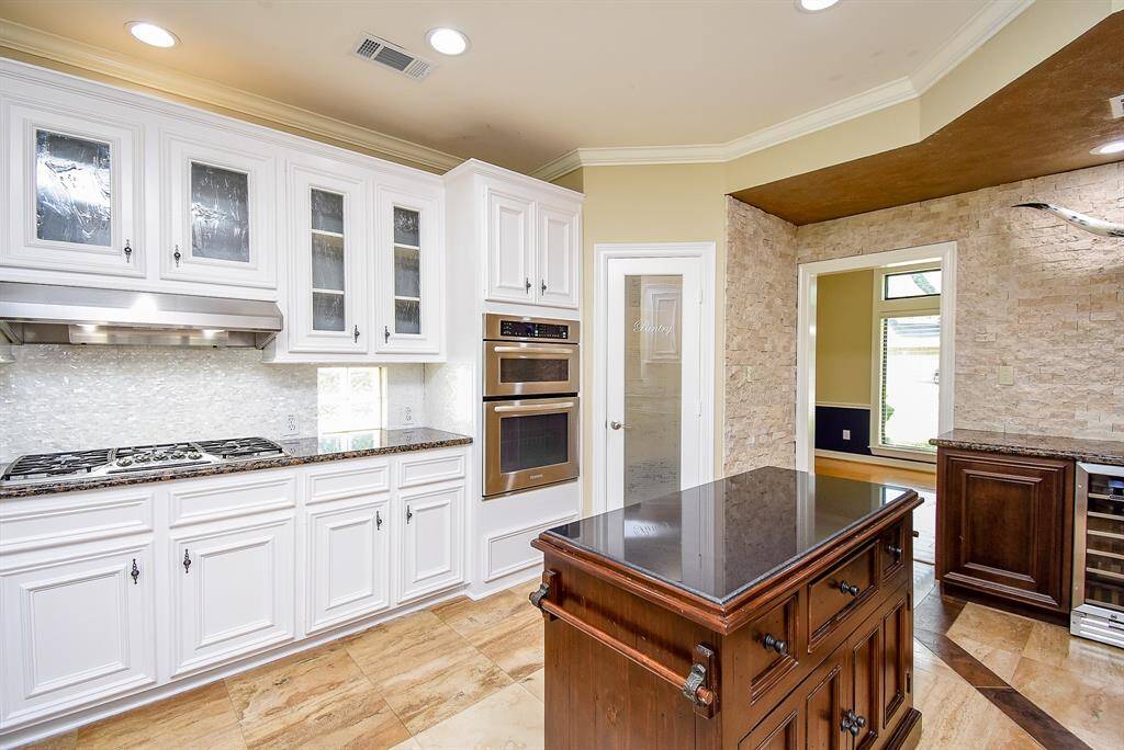 The seller added 6-kitchen upper cabinets modified with seeded glass inserts. The kitchen is well lit with recessed can lights! Updated hardware on cabinets and crown molding