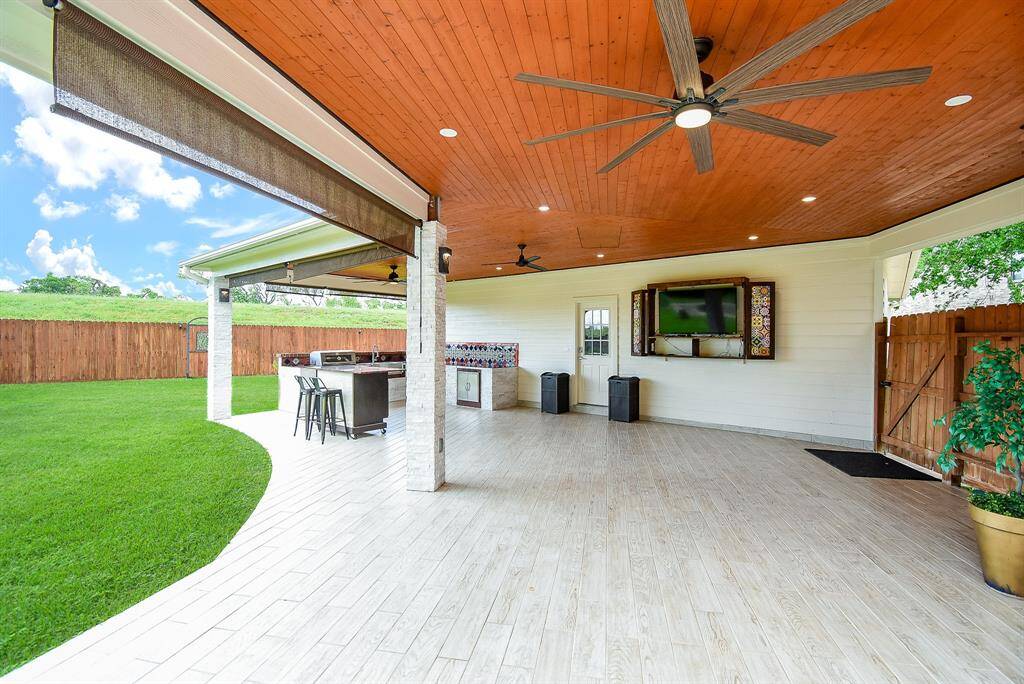 Outdoor kitchen and patio custom built with granite countertops, Included o A pine plank ceiling stained to a cedar finish, Attic storage space over the enclosed patio with pull-down stairs access, Custom built TV enclosure with TV included.