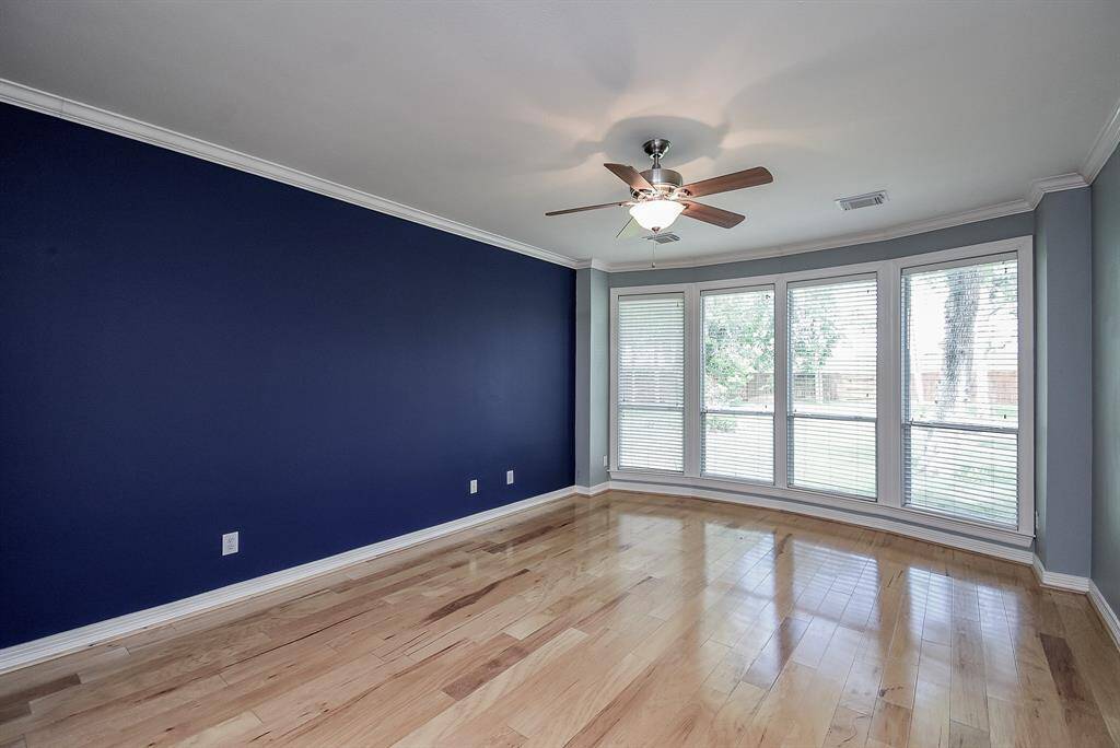The owner's retreat has a curved wall of windows with serene views of the backyard. Crown molding and designer paint tones!