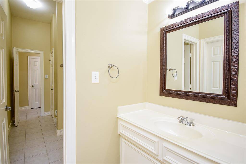 Bedroom 2 and 3 share this Hollywood bath. Each bedroom has a sink/vanity area with updated frame mirror and cabinet storage.