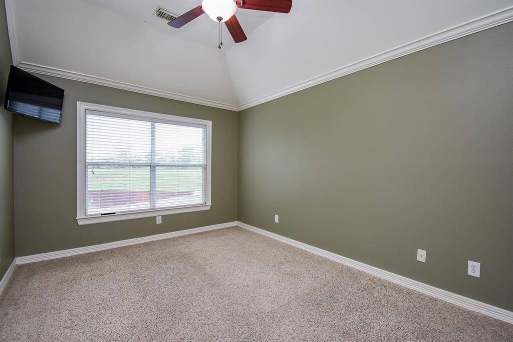 Bedroom 4 overlooks the backyard and s located on the opposite side of the home from bedrooms 2 and 3. It has ample closet space, crown molding and a ceiling fan!