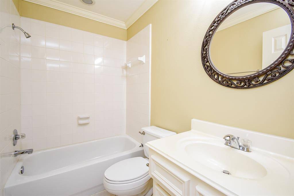 The third full bathroom is located between bedroom 3 and the large game room! It also lends to plenty of storage space, tile floors and a framed round mirror.