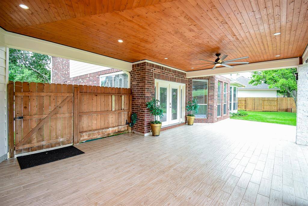 Amazing custom covered patio with tile plank floors, pine plank ceiling stained to a cedar finish, attic storage space over the enclosed patio with pull-down stairs access, three large ceiling fans, recessed can lights!