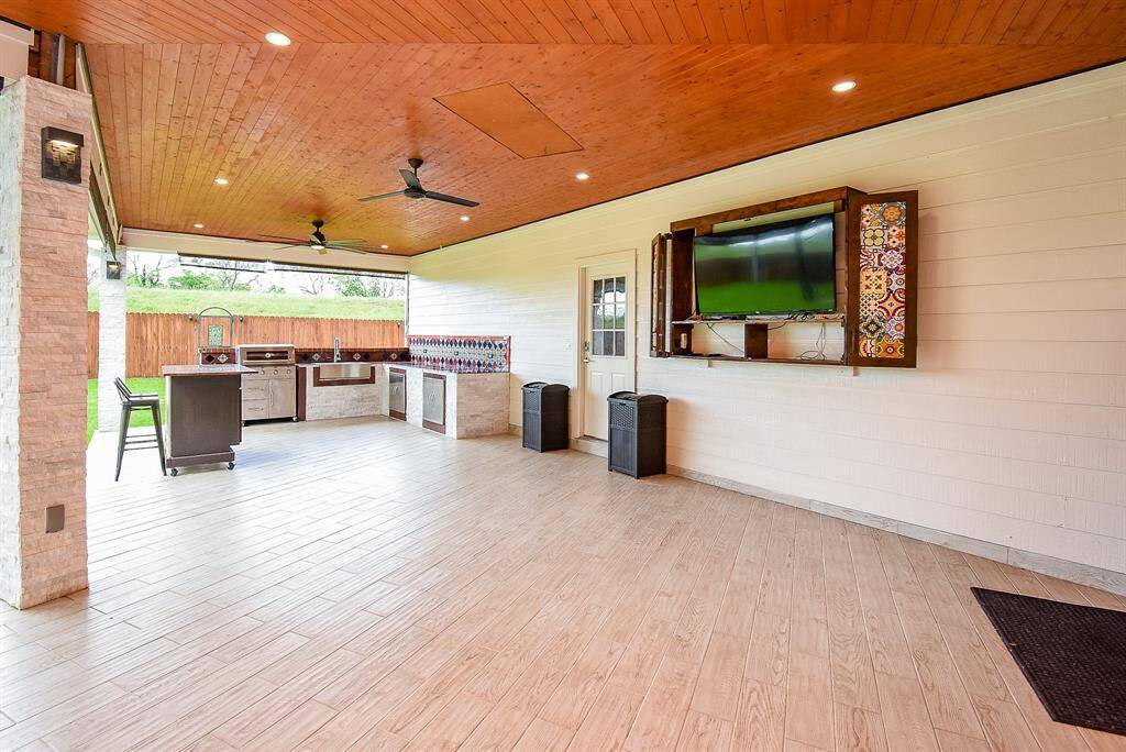 Custom built TV enclosure with TV included, support columns adorned with stacked rock from floor to ceiling with outdoor sconce lights! Five - Coolio roll down shades