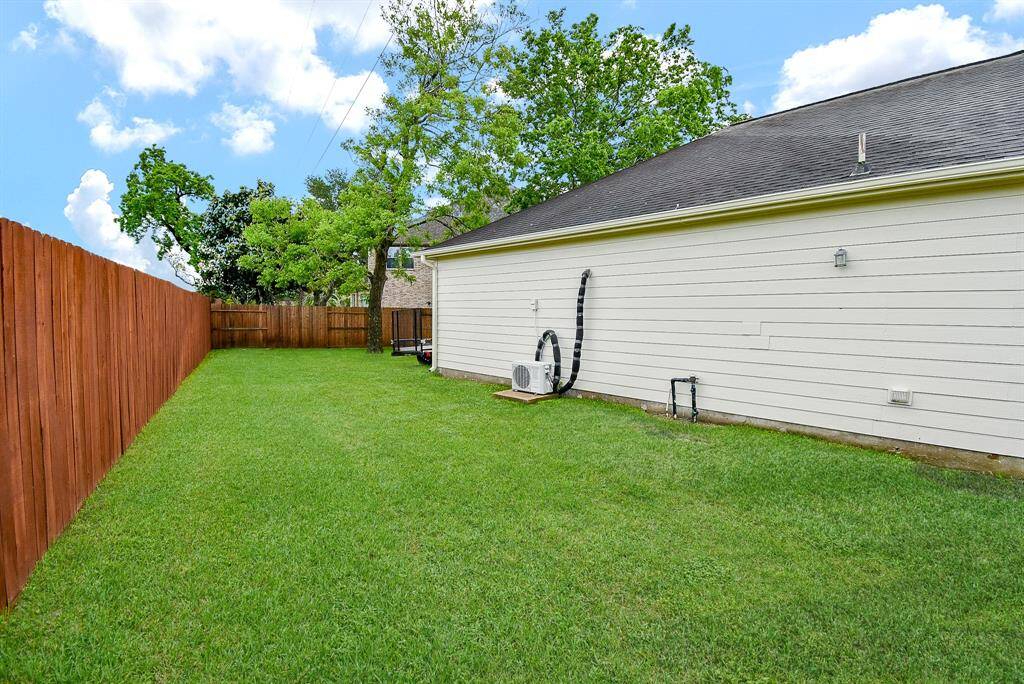 Behind the garage is a wide open space for gardening or storage.
