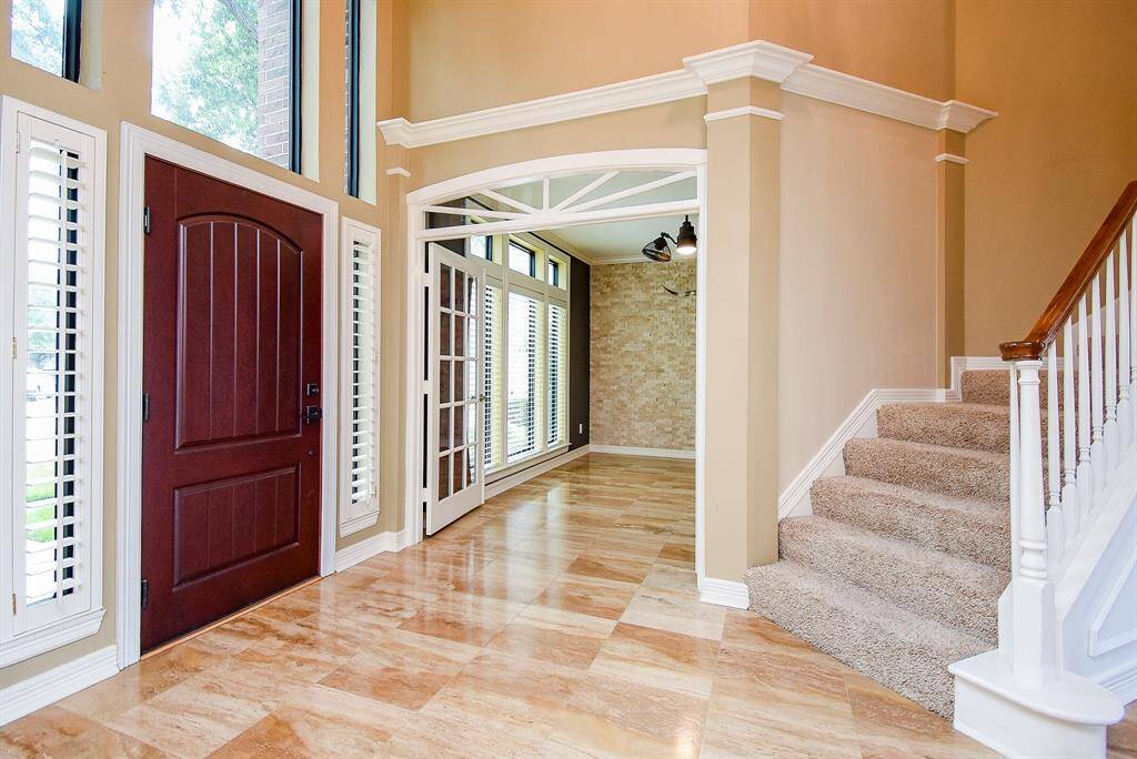 Guests will be impressed with the beautiful travertine floors throughout the home. The study is located to one side of the entry opposite of the formal dining area.