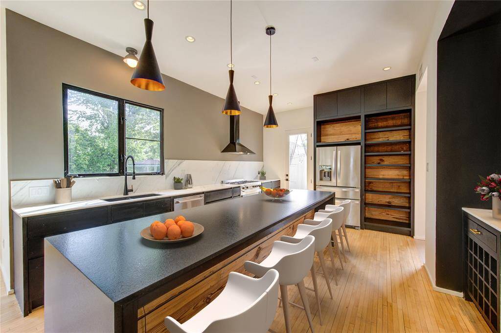 Experience modern elegance with a touch of history in this stunning kitchen, featuring original 1920s shiplap and a spacious waterfall island with ample seating. Virtually staged for your inspiration.