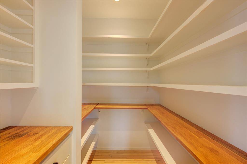 Spacious walk-in pantry with ample shelving and countertop space.