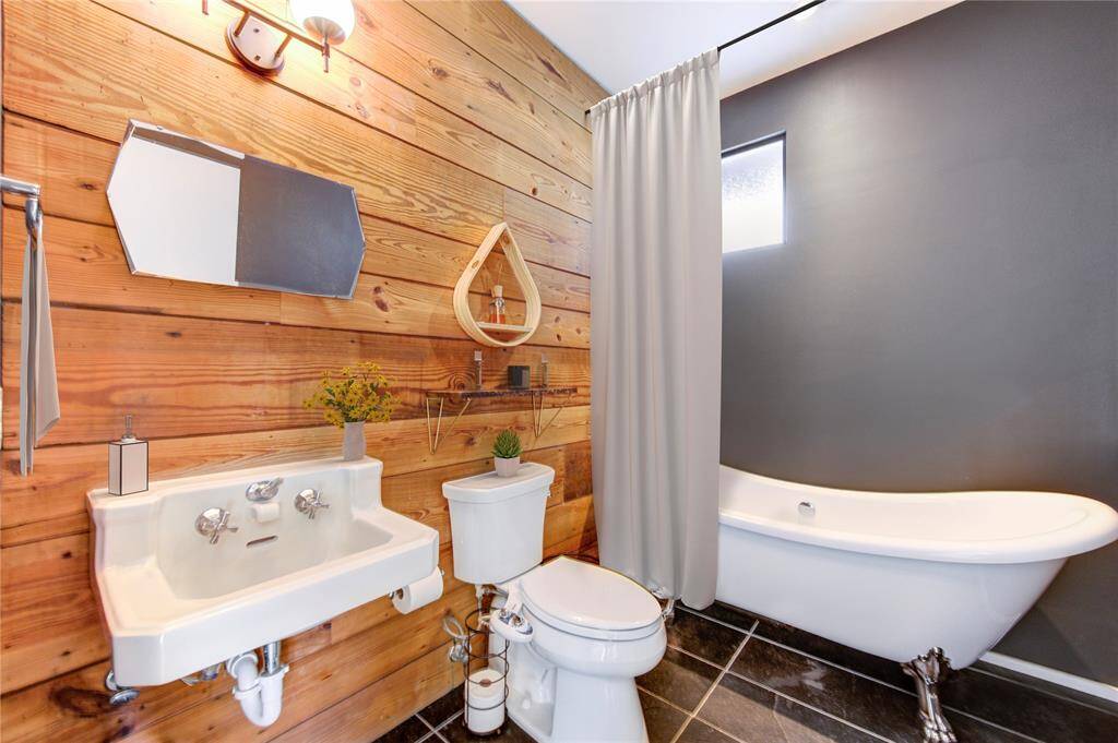 This beautifully designed space seamlessly blends vintage 1920s elements, like the sink and original shiplap, with modern touches, creating a charming fusion of old and new.