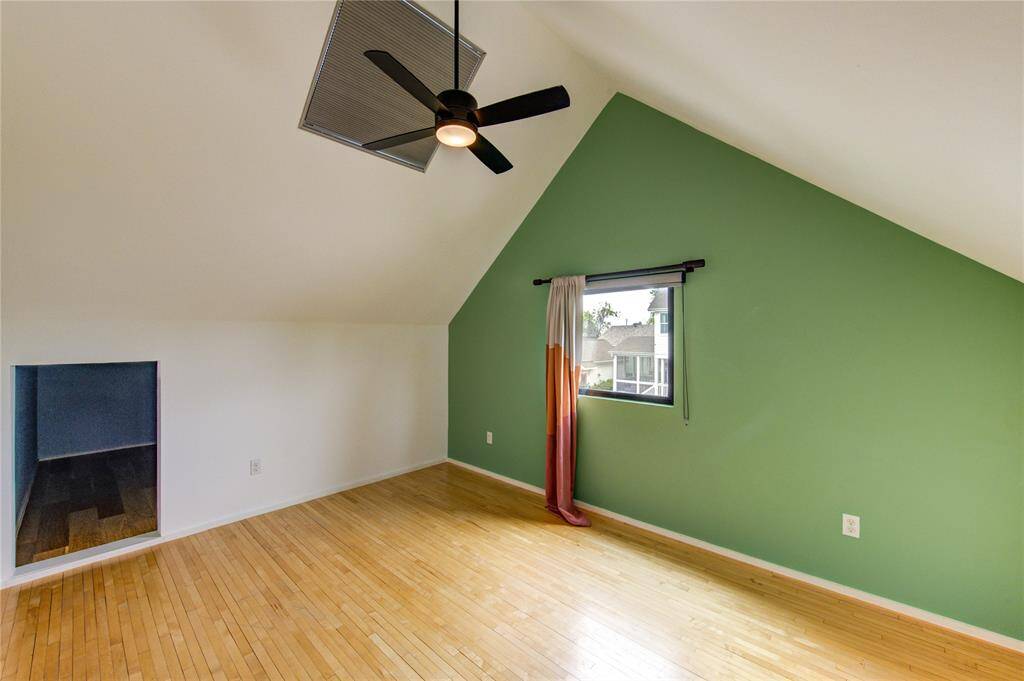 Secondary bedroom featuring vaulted ceilings, a skylight, and downtown views. Ideal for guests or children, with ample space for a playroom or hobby storage.