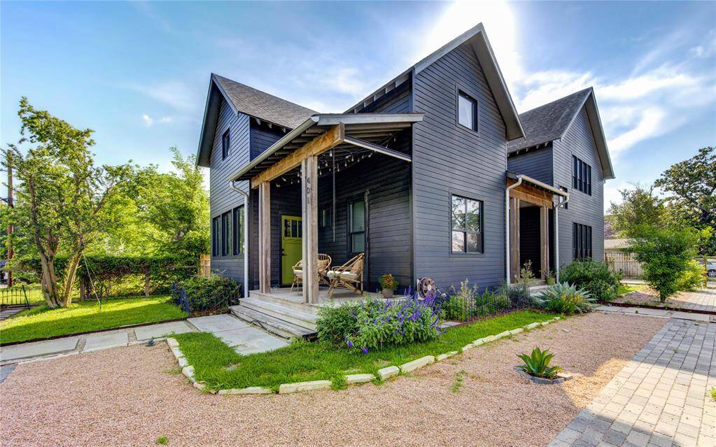 Spacious patio ideal for entertaining, complemented by cozy garden beds and lush, native plants. (Virtually staged)