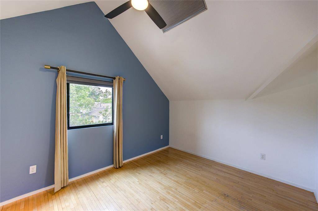 This secondary bedroom features soaring ceilings and a cozy desk nook, perfect for productivity.