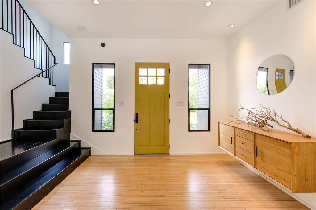 Welcome to a bright foyer featuring custom cabinetry and discreet storage closets.