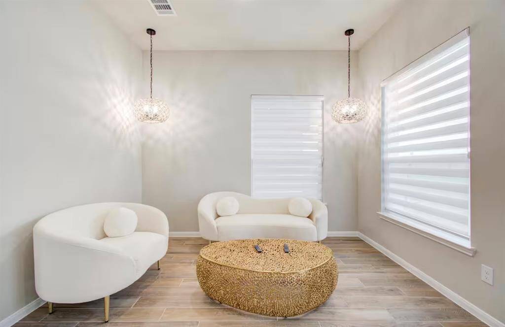 The sitting area has large windows and beautiful lights.