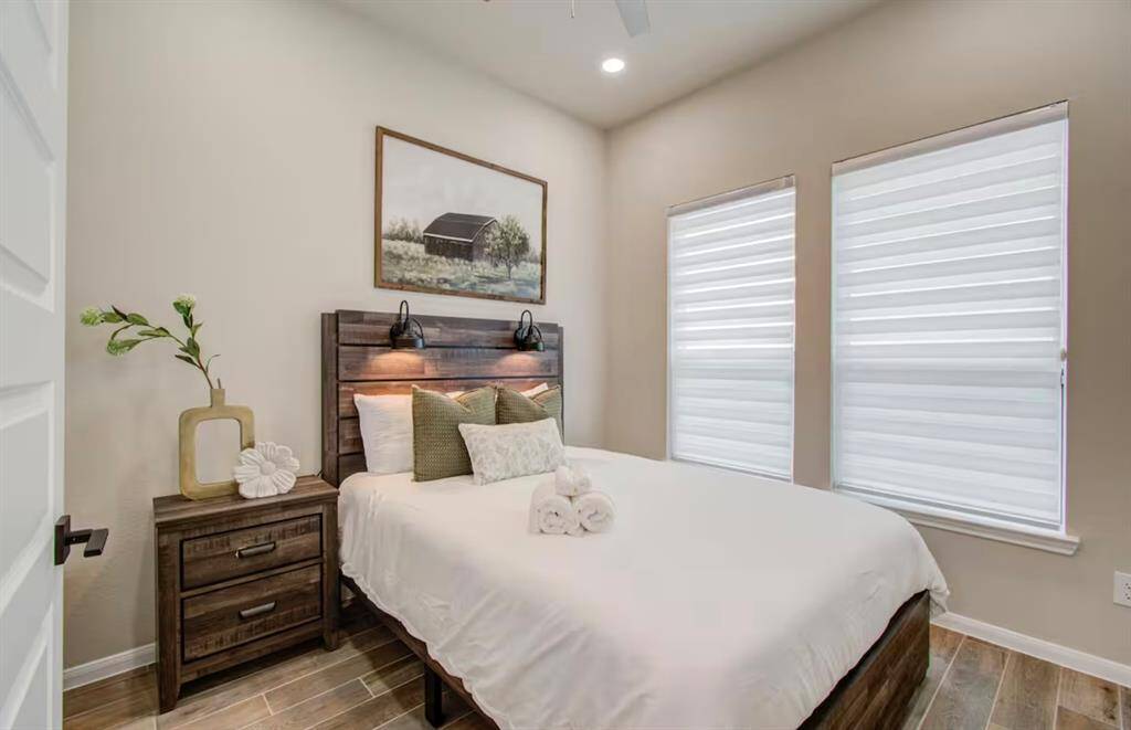 Third bedroom features large windows and a ceiling fan.
