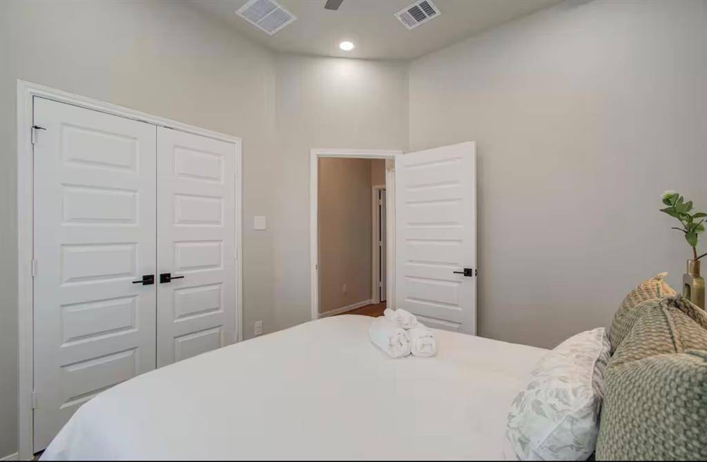 Third bedroom features large windows and a ceiling fan.