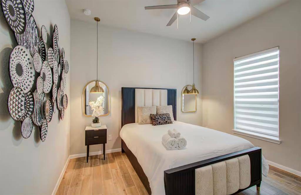 Fourth bedroom features awindow, custom lighting, and ceiling fan.