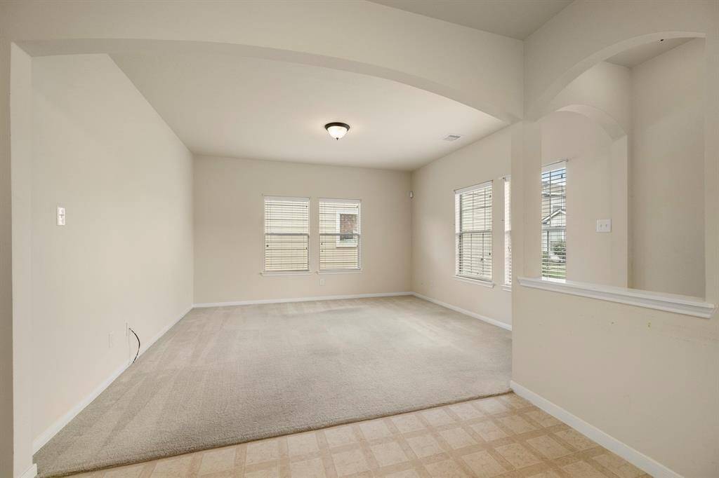 From the dining area, this closer view of the living space showcases the beautiful archways that add character to the home. The open design creates a seamless flow between the kitchen, dining, and living areas, offering a spacious feel while maintaining a sense of separation and charm.