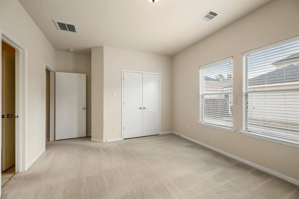 Another view of the primary bedroom highlights its spacious layout and natural light. The large windows create a bright and inviting atmosphere, offering a peaceful retreat at the end of the day.