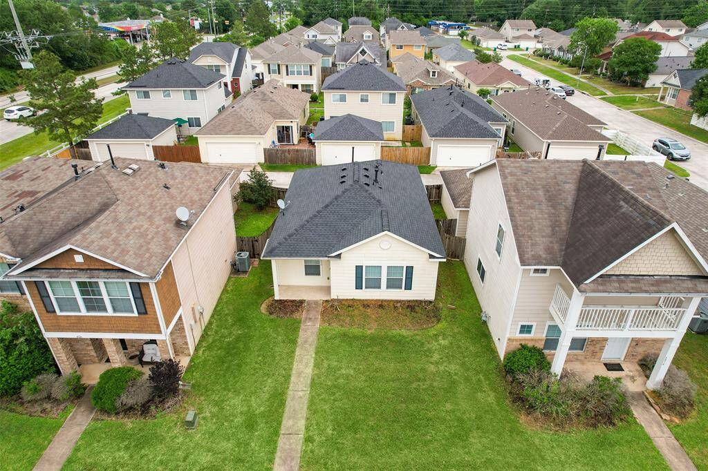 This aerial view showcases the home's unique location, with a convenient alley behind and a sidewalk in front that separates it from the neighboring home. The layout provides both privacy and easy access, offering a peaceful and well-connected setting.