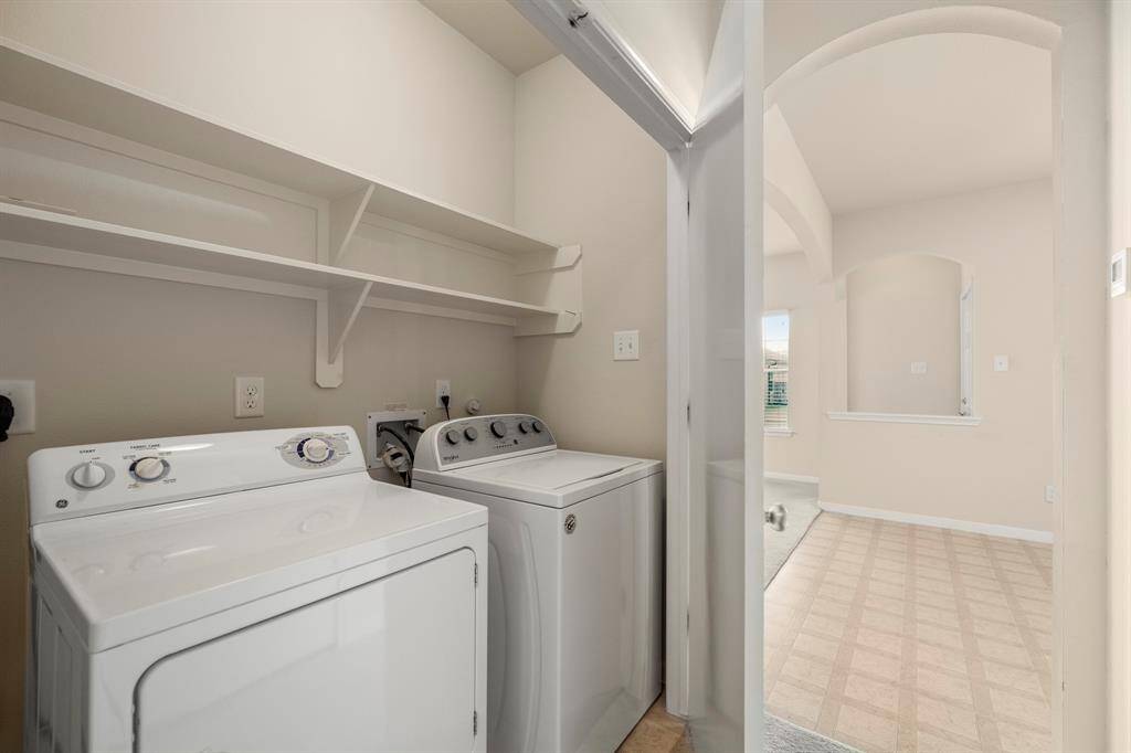 The laundry closet is conveniently tucked behind double doors in the hallway near the kitchen. It comes equipped with a washer and dryer, making laundry day a breeze. Built-in shelves above provide additional storage space for supplies, helping to keep everything organized and within reach.