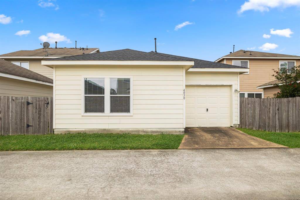 A straight-on view of the rear of the home from the alley shows the 1-car garage, providing convenient, private parking. The garage is easily accessible and adds functionality to the home, offering storage space and shelter for your vehicle.