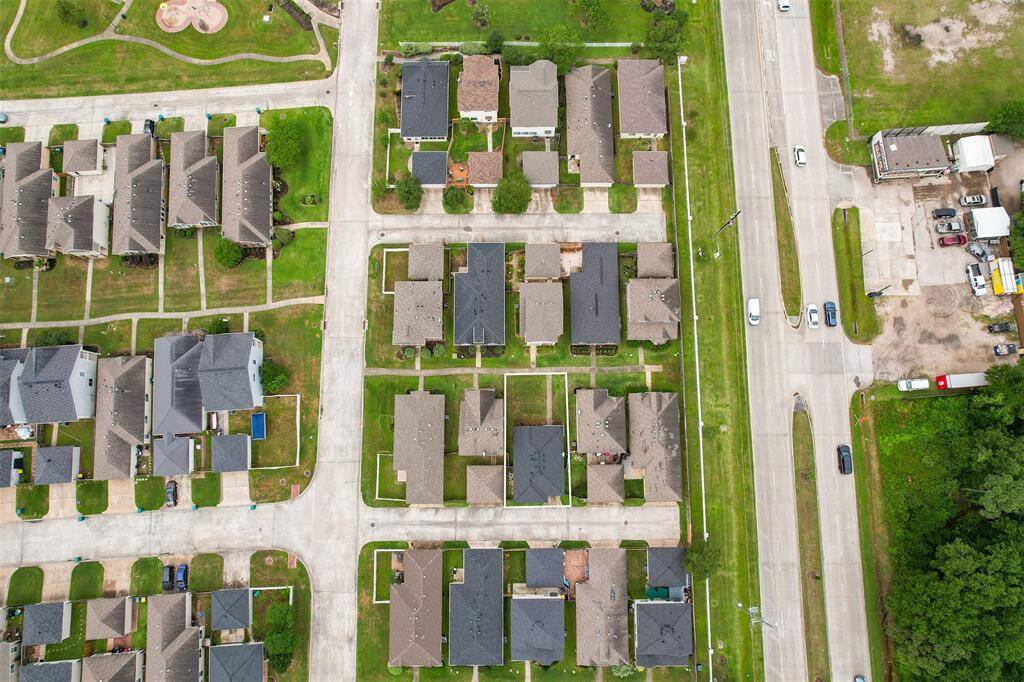 This even further out aerial view provides a broader perspective, showing the block, the alley behind the homes, and the green space across the sidewalk. Spring Steubner is also visible nearby, offering a sense of the home's proximity to major roads and easy access to surrounding areas.