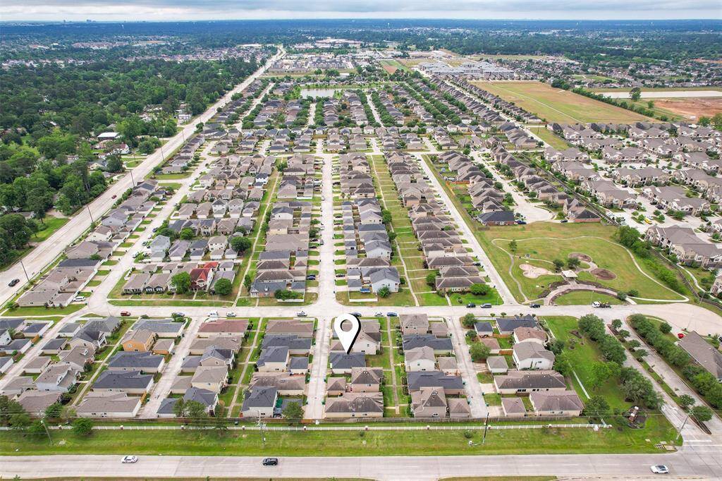 This aerial view offers a broader look at the community, showcasing the layout of the neighborhood and its surrounding areas. It highlights the convenient access to local roads and gives you a sense of the well-connected environment around the home.
