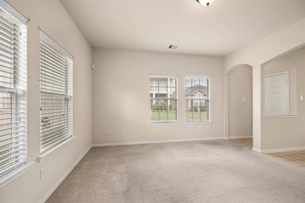 This view of the living room highlights the abundance of natural light that fills the space, creating a warm and inviting atmosphere. The large windows allow for plenty of sunshine, making it a bright and welcoming area to relax or entertain.