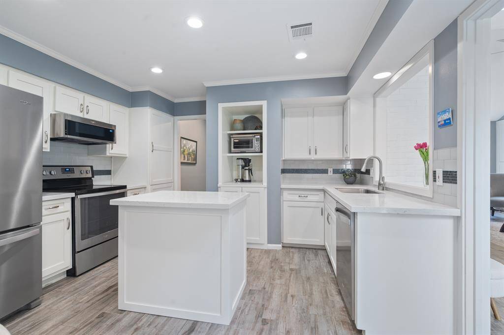The kitchen is equipped with an island, pantry, and coffee bar, all accented by elegant stone counters. Ample cabinet space ensures plenty of storage for all your kitchen essentials.