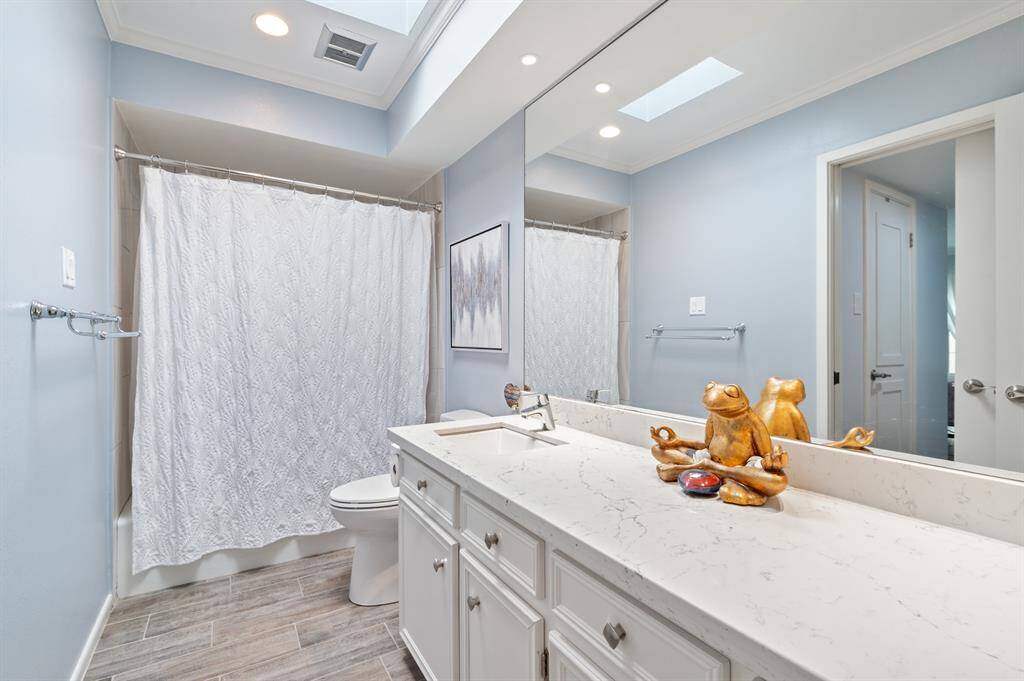 The secondary bathroom offers generous cabinet and counter space, ensuring plenty of storage and convenience. A tub-shower combination provides both relaxation and practicality in this well-appointed space.