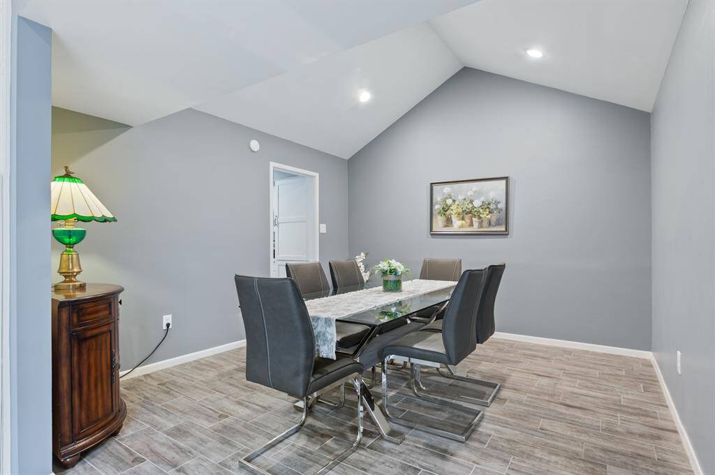The dining room boasts impressive vaulted ceilings, creating an open and airy atmosphere. Canned lighting highlights the space, adding both functionality and ambiance for any occasion.