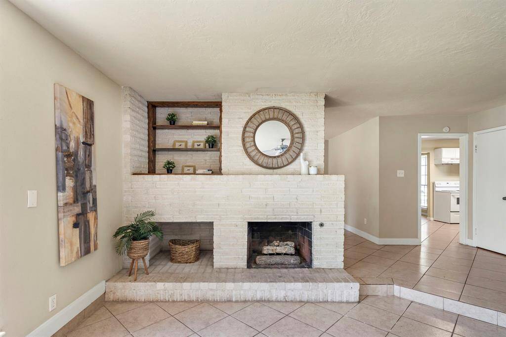 The brick wood burning fireplace provides a gorgeous focal point for the room, with wood shelving to displace photos and treasures.