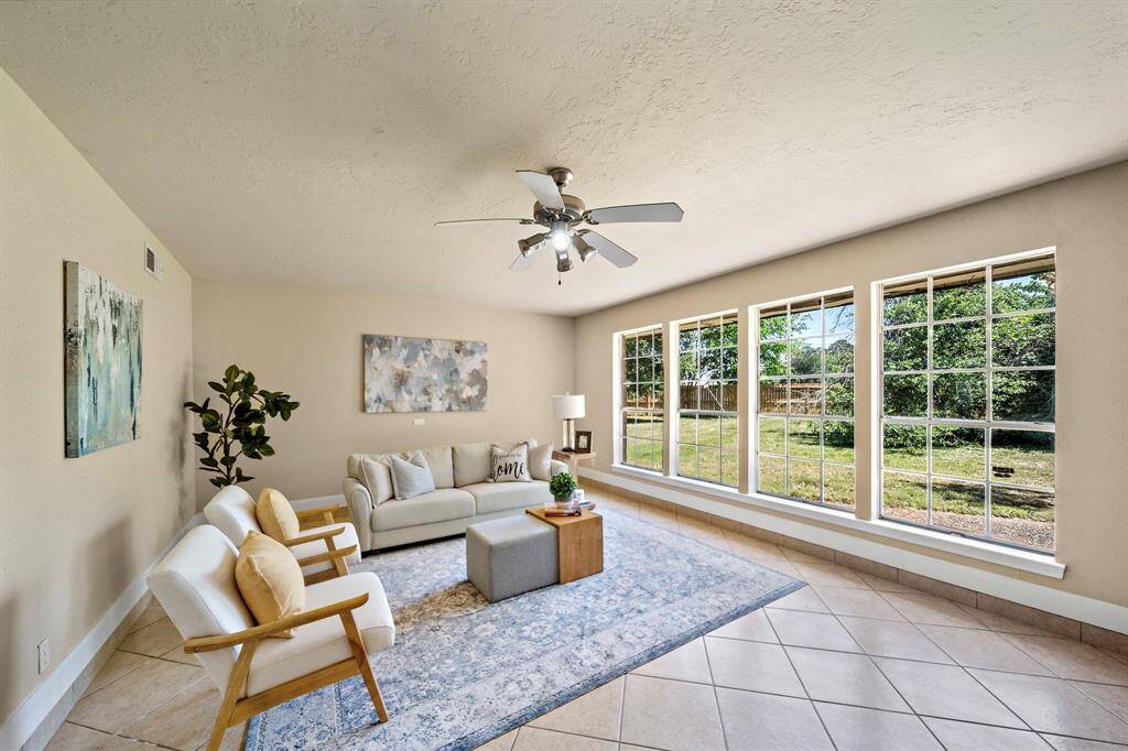 Massive windows overlook the almost half acre lot with lush greenery.