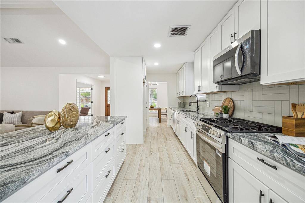 A chef’s dream, this fully updated kitchen features brand-new cabinetry, gleaming stainless steel appliances, a gas range, tile backsplash, and a sleek pull-down faucet—all designed for style and function.